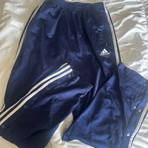 Vintage 90s navy adidas track pants with white stripes and snap buttons